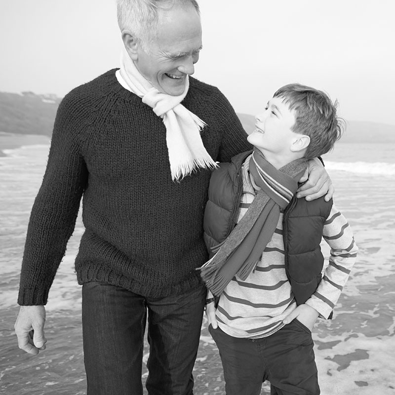 Grandpa with grandson laughing by sea