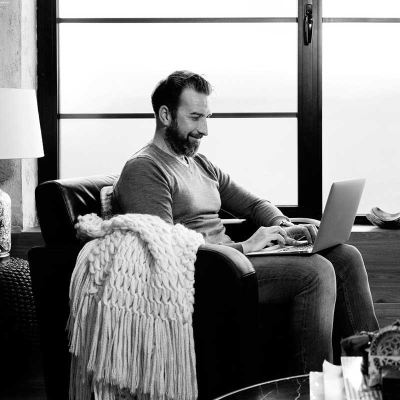 Man contentedly sitting in front of notebook